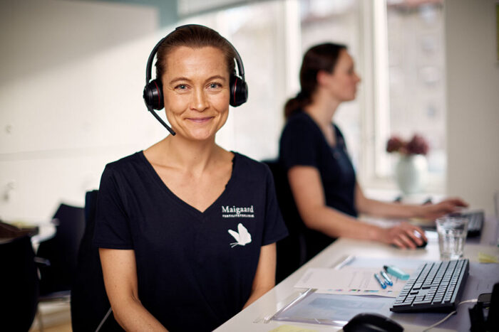 Maigaard staff member wearing a headset at the clinic reception